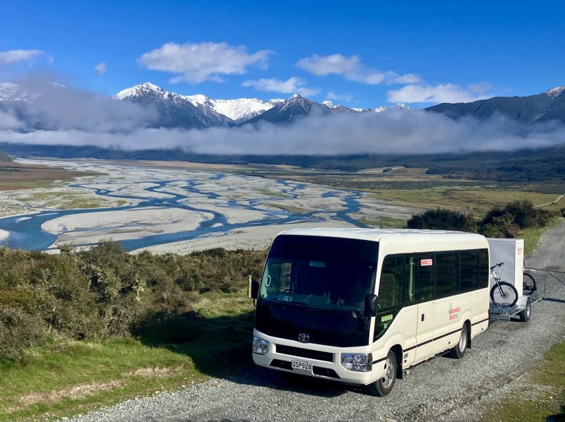 The Adventure South support bus and bike trailer above a braided river
